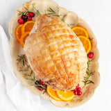 cooked boneless turkey breast on a serving dish with oranges
