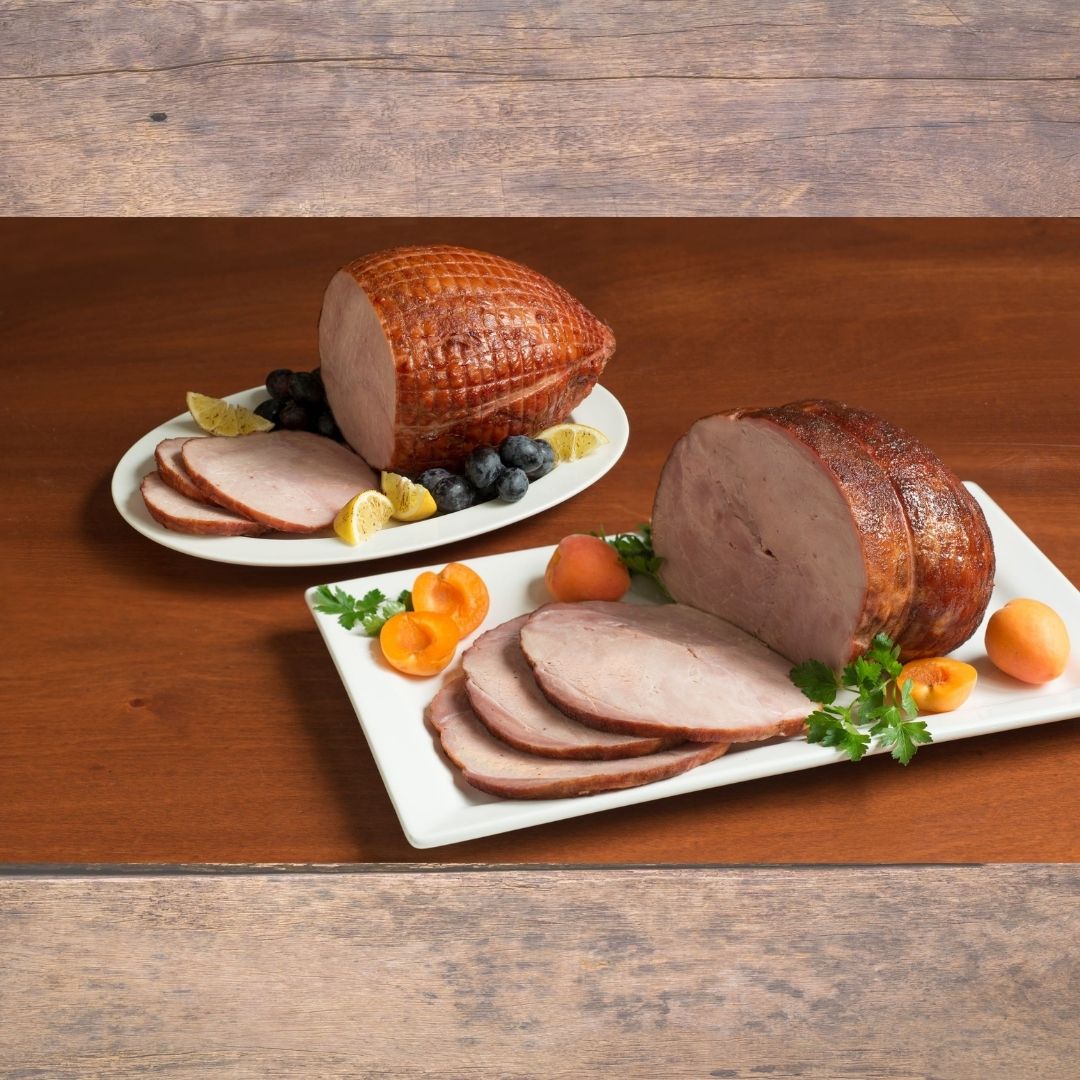 two sliced hams garnished on plates