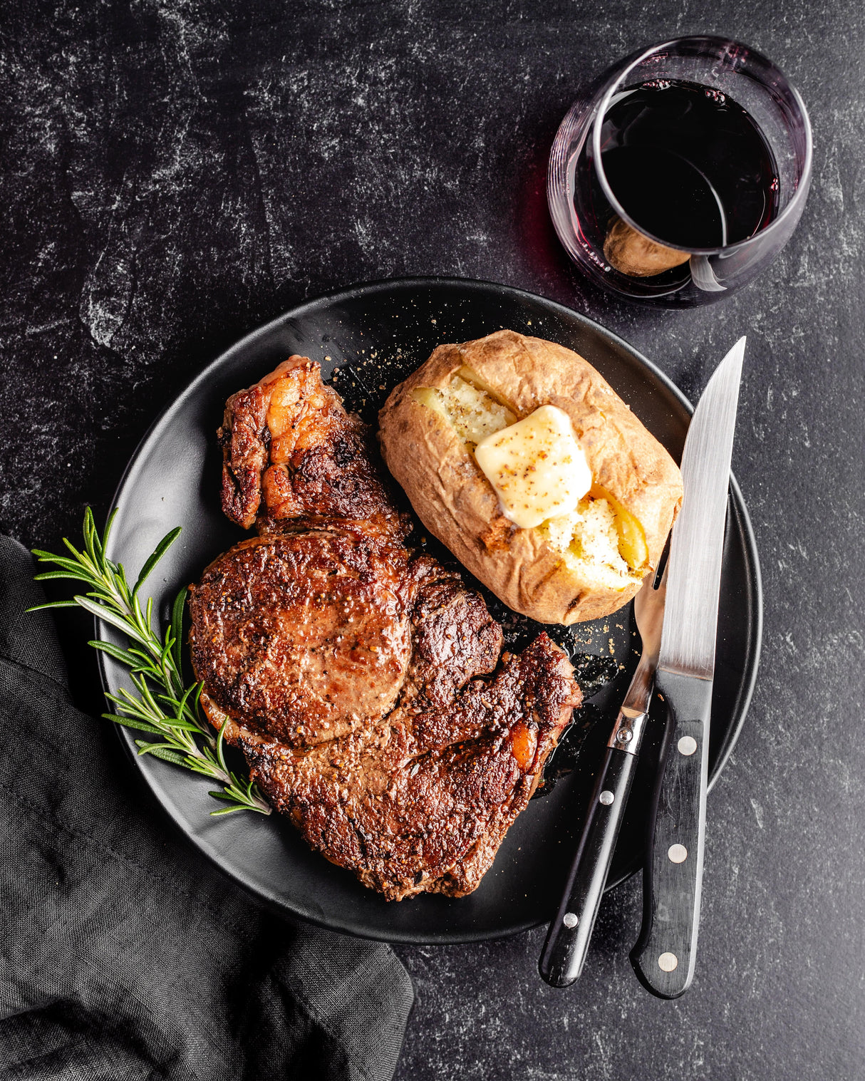 a grilled ribeye steak with baked potato