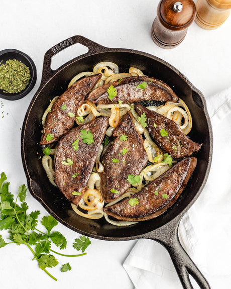 beef liver with onions in a cast iron pan
