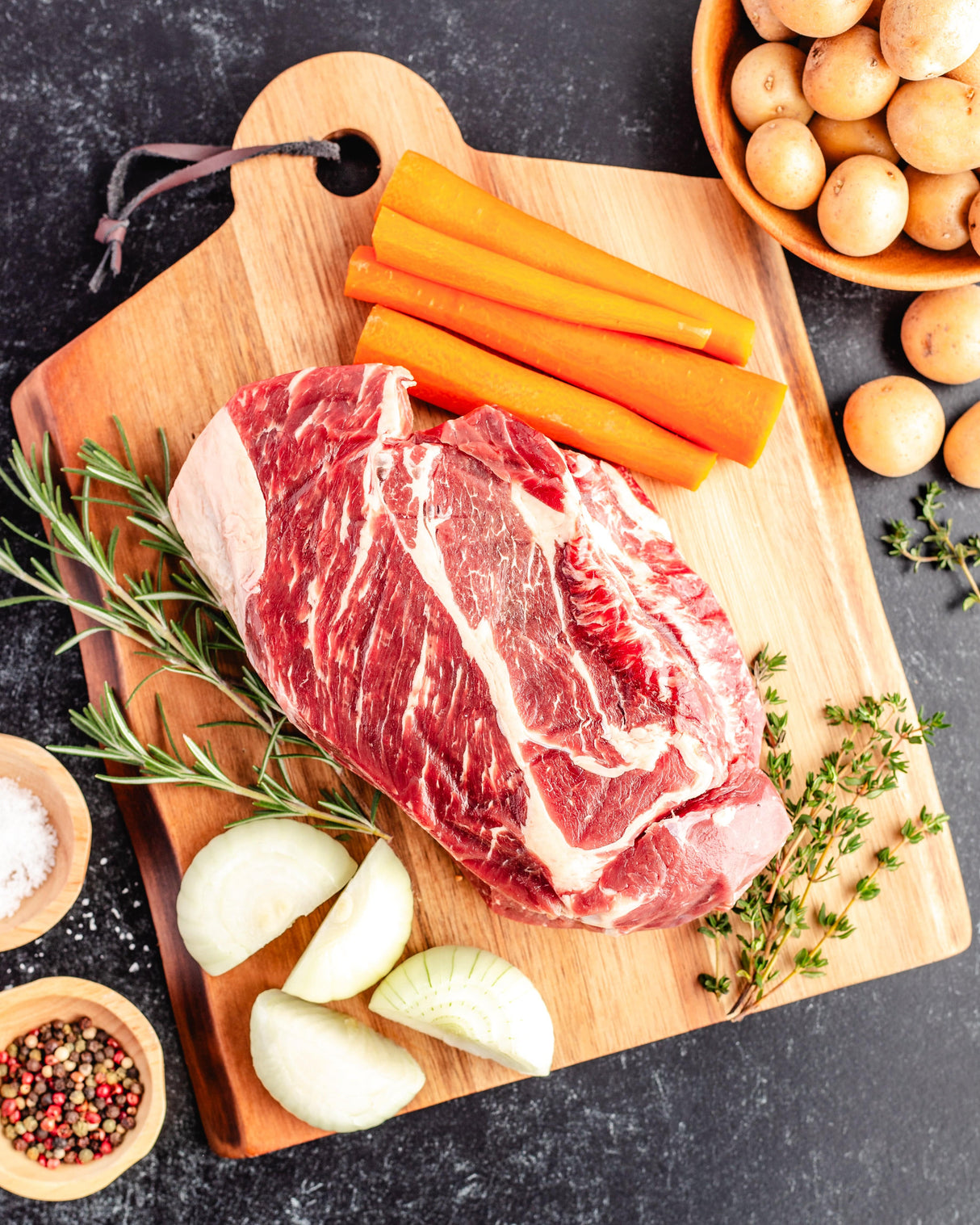 a well marbled chuck roast with carrots and onions