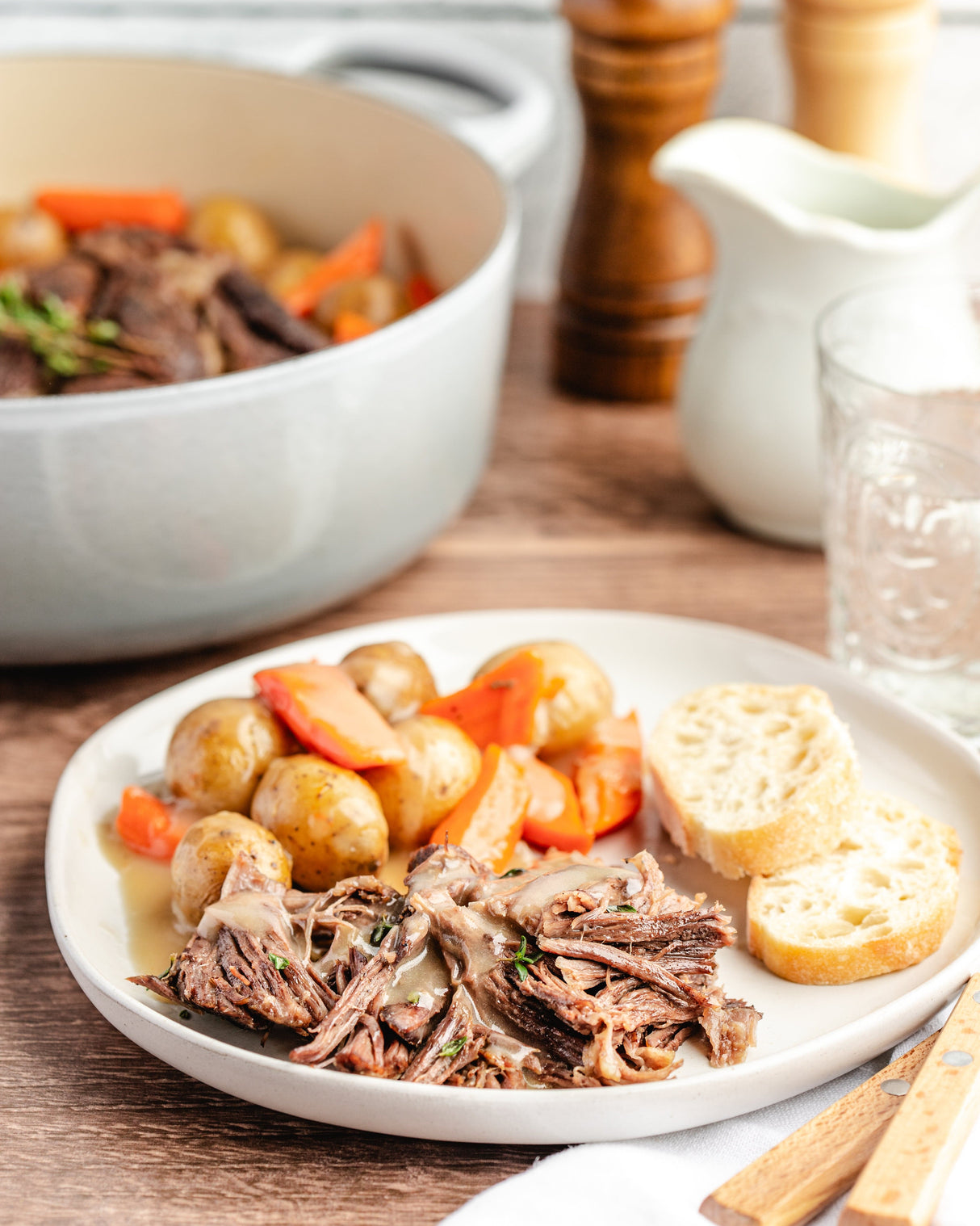 a plate of chuck roast with gravy and vegetables