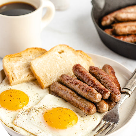 fried sausage links on a plate with eggs and toast
