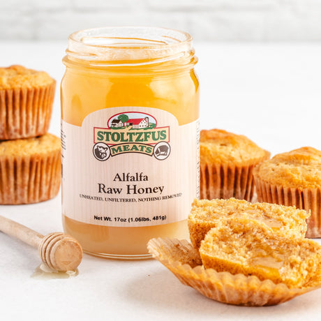 a jar of raw honey with bran muffins