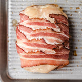 a bacon wrapped cordon bleu on a cooking tray